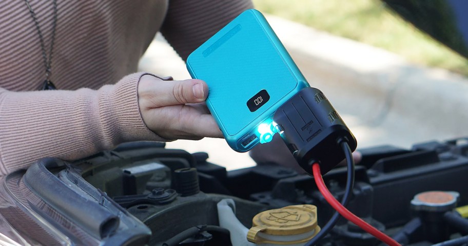 jump starting a car with a blue power bank