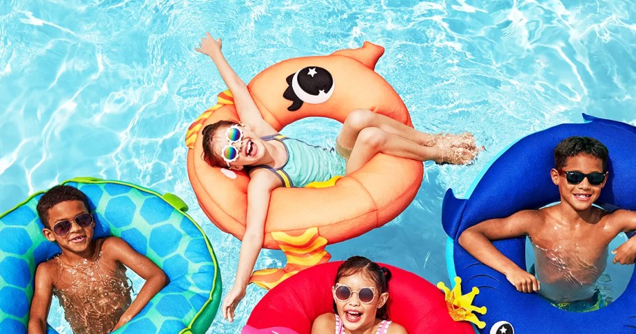 kids sitting in animal pool floats in pool