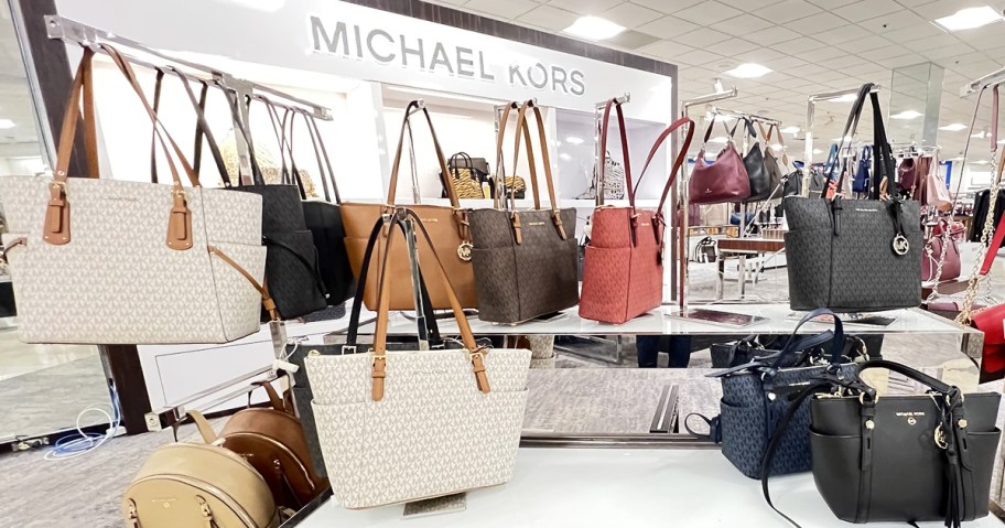 display of Michael Kors tote bags in store