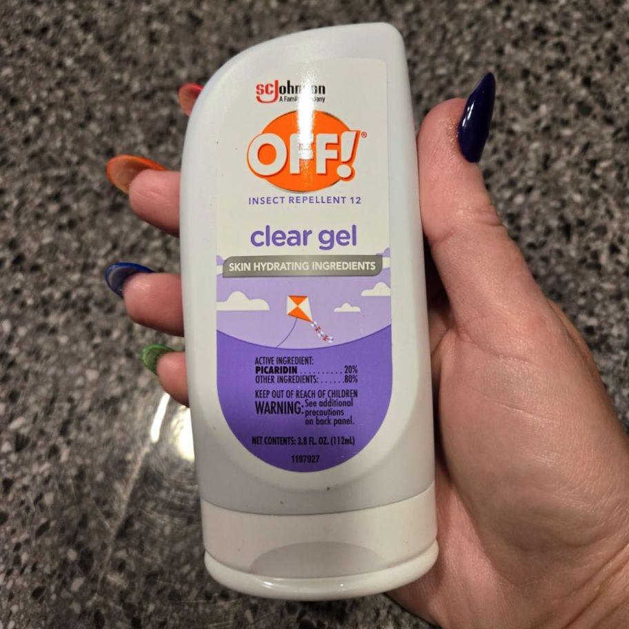 a hand holding a bottle of bug repellent gel