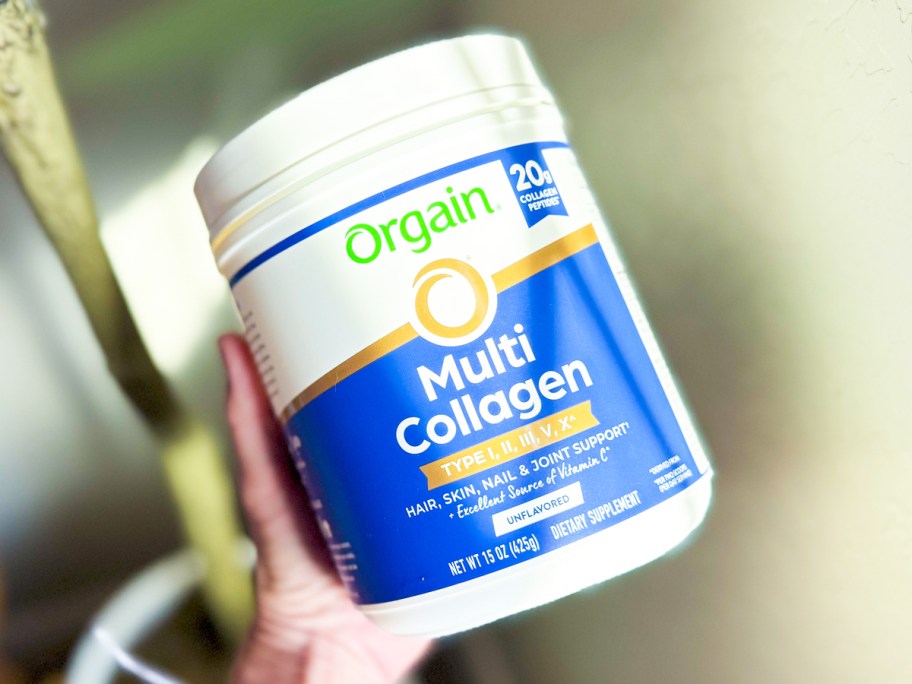 hand holding a white and blue jar of Orgain Hydrolyzed Multi Collagen Powder