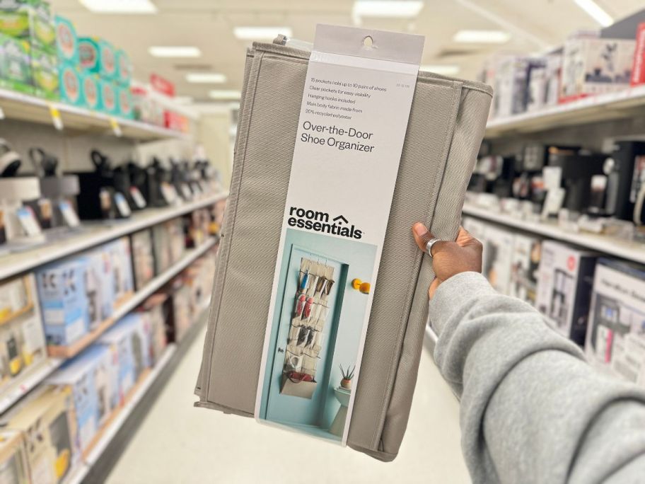 Room Essentials 15-Pocket Over the Door Hanging Shoe Organizer package being held by hand in store