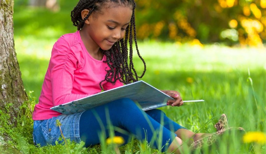 a young girl reading as part of the Scholastic summer reading program