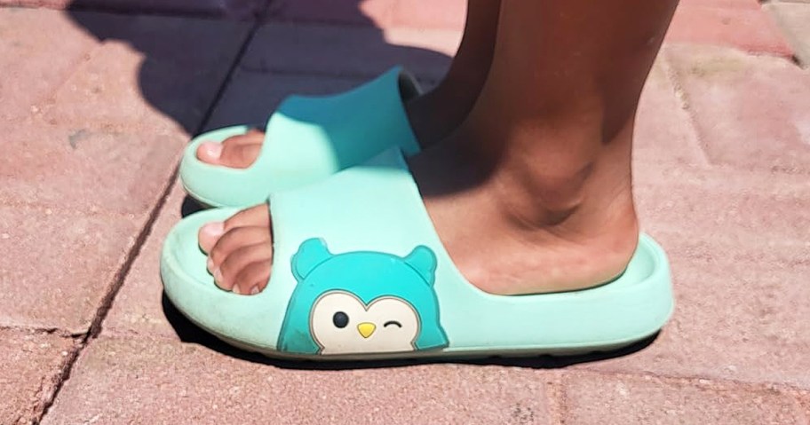 child wearing teal Squishmallows Kids Slides with owl on side