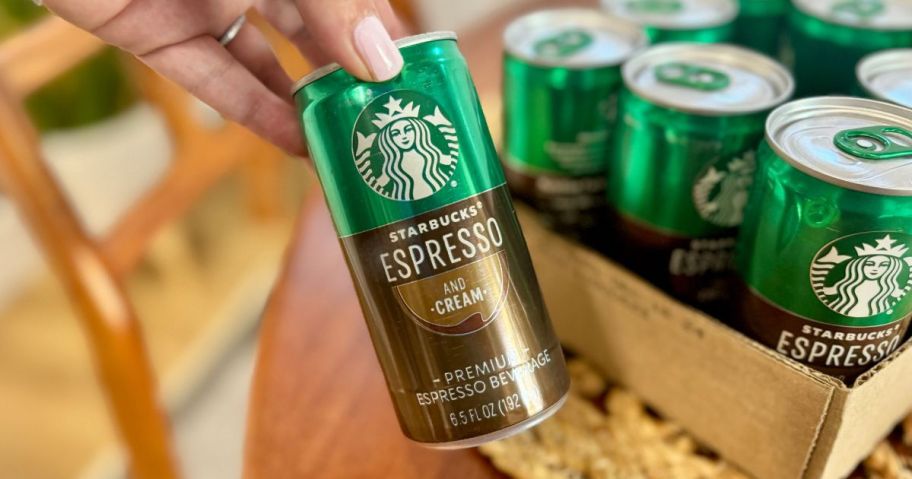 Starbucks Espresso being held by a woman at a table