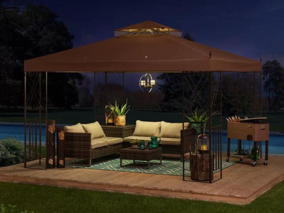 Sunjoy Henley 8'x5' Steel Grill Gazebo at night on the patio