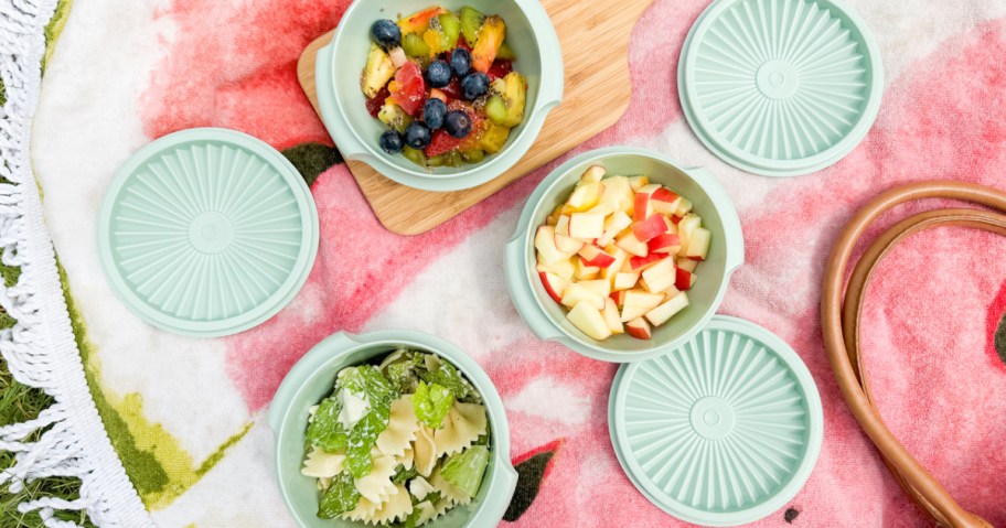 tupperware with fruit on picnic blanket