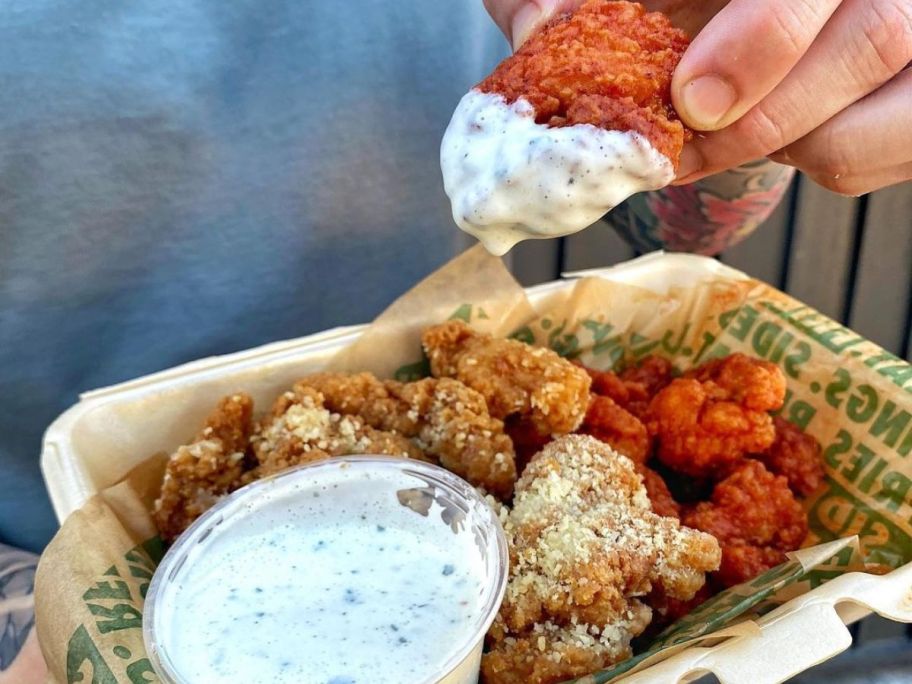 A takeout container filled with Wingstop Boneless Wings