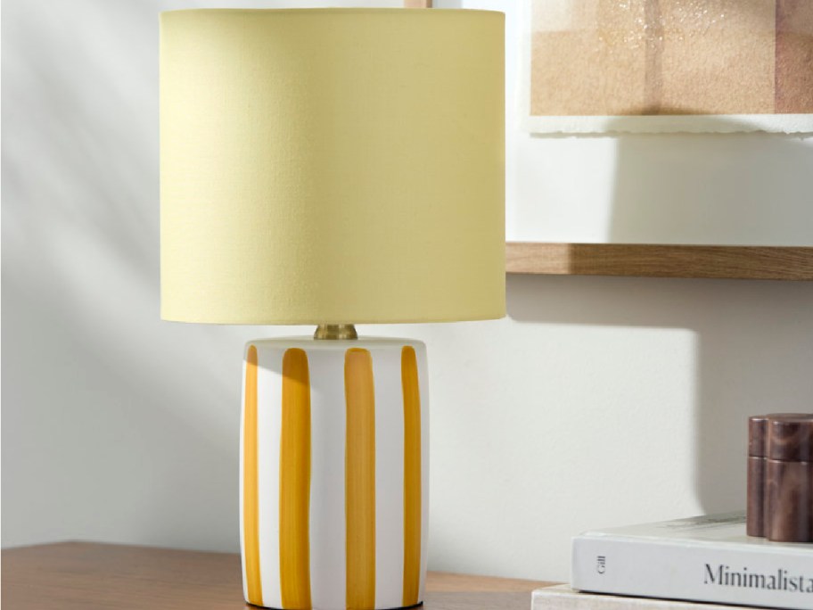 yellow lamp from wayfair with a striped base displayed next to books