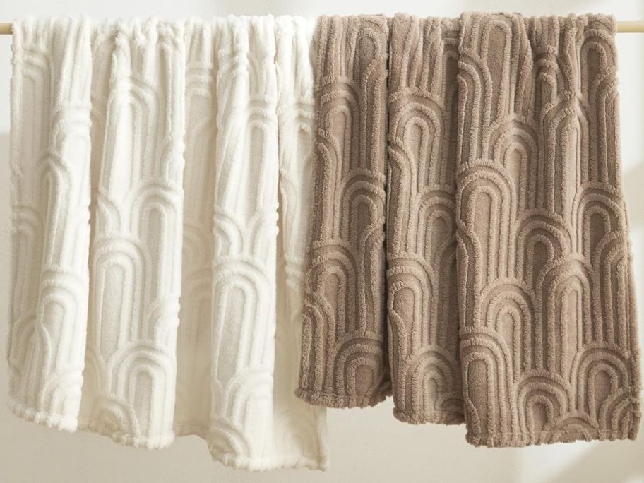 two bedsure fleece throw blankets hanging on a rod