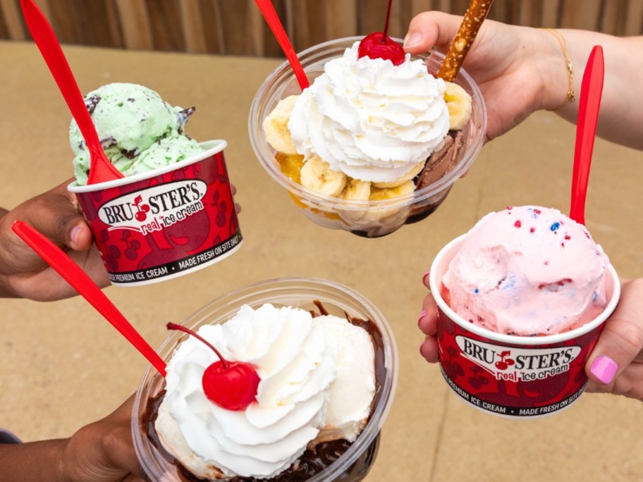 4 hands holding cups of ice cream