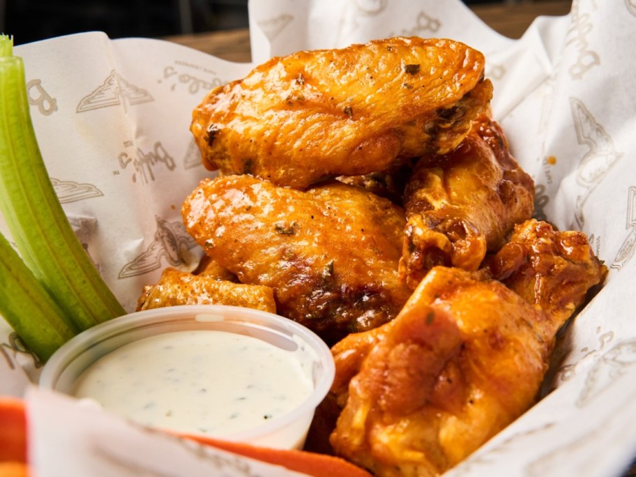 chicken wings next to celery, carrots, and ranch
