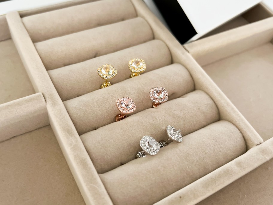 three pairs of stud earrings in jewelry box