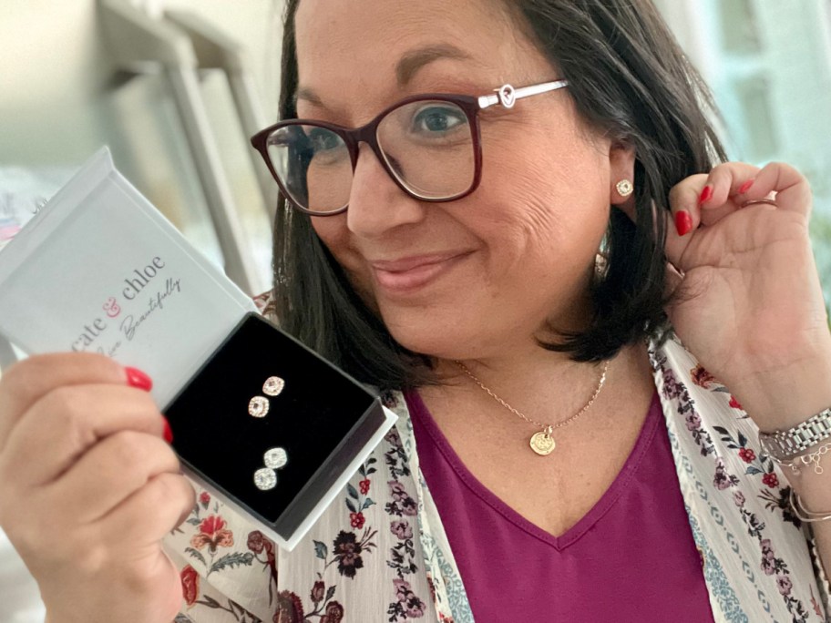 lina wearing stud earrings and holding gift box