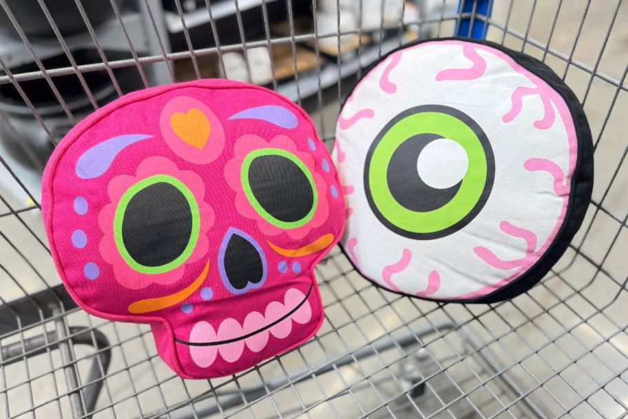 candy skull and eyeball throw pillows in a shopping cart