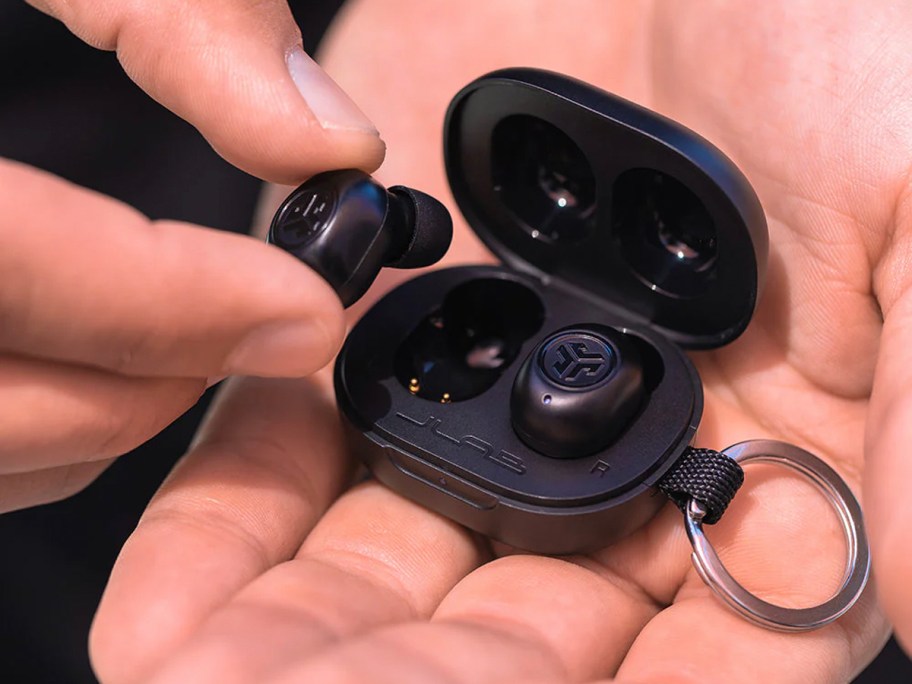 hand holding mini black jlab earbuds