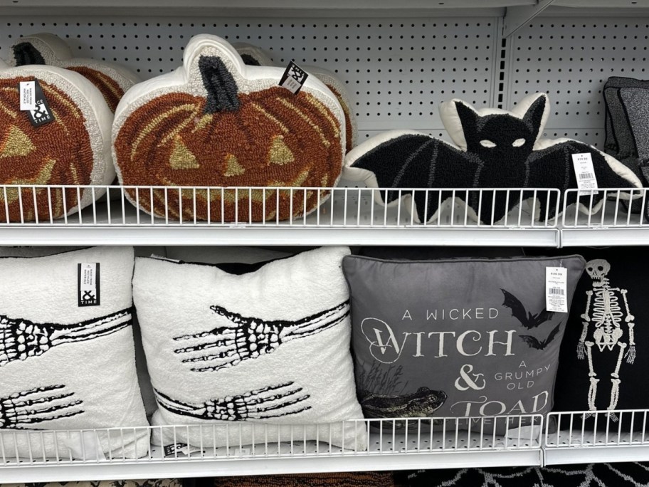 Halloween themed pillows on display in a store - Jack-o-lantern, Bat, and more
