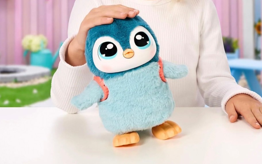 girl patting toy penguin on head