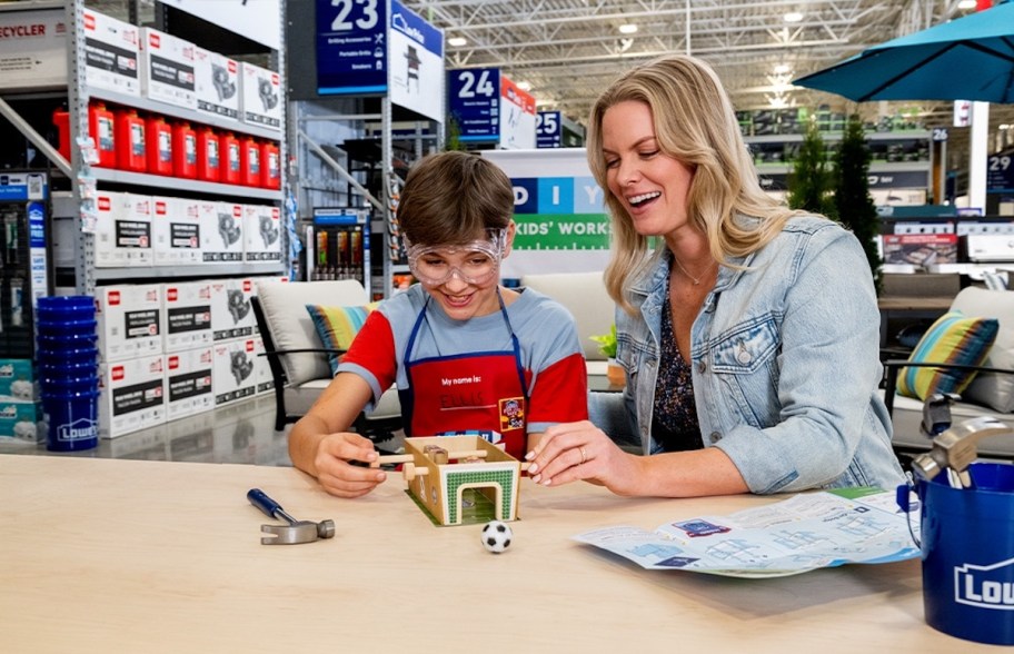 mom and son sitting at desk making lowes craft