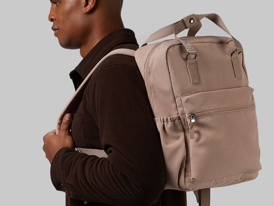 man wearing a backpack in beige