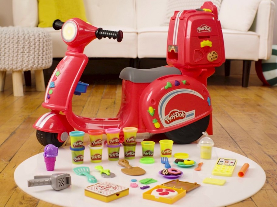 red play doh scooter with accessories laying out in front of it