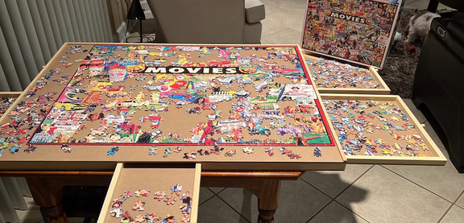 puzzle table with movie puzzle on top with drawers open