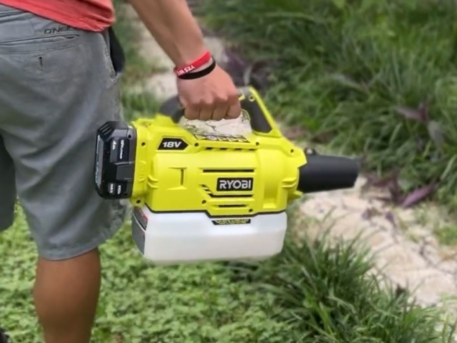 man spraying weed killer on yard with a Ryobi fogger/mister tool