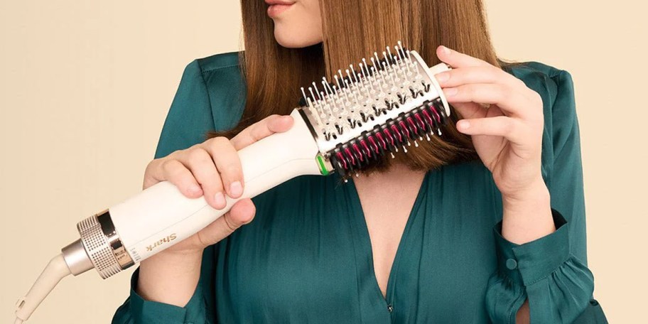 woman using shark blow dryer comb on hair