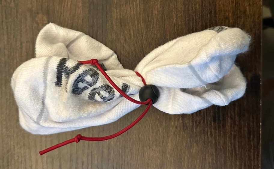 pair of white socks with red elastic tie on front