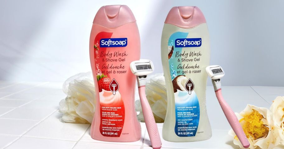 a strawberry and a coconut softsoap body wash and shave gel bottle with loofas and razors next to them in bathroom
