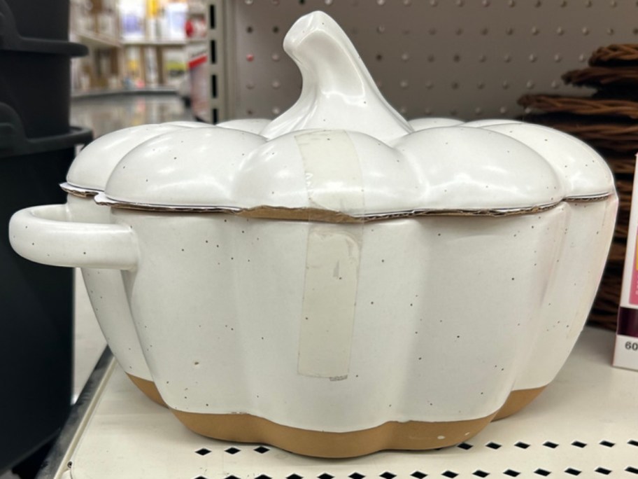 a large white and brown pumpkin shaped baking dish on a store shelf