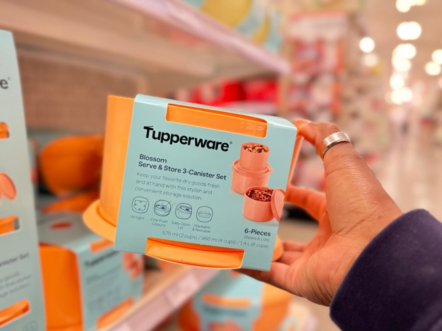 hand holding a set of medium size Tupperware containers in bright pastel orange