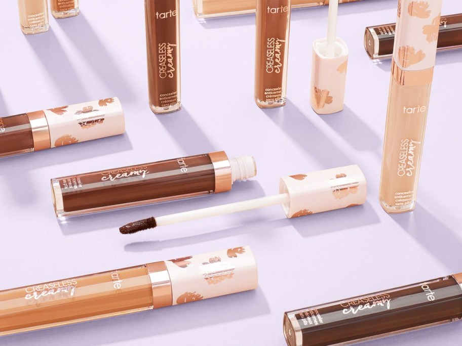 multiple tubes of tarte Creaseless Creamy Concealer on purple background