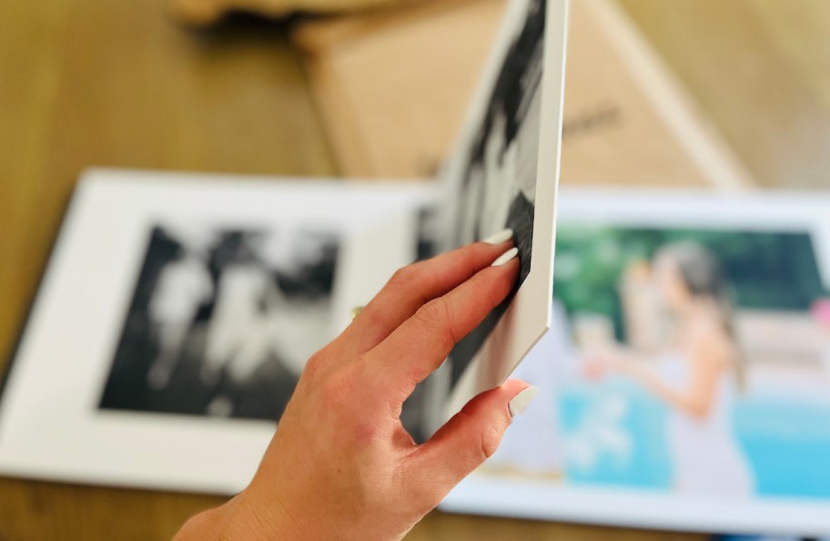 hand holding thick page of luxury photo album