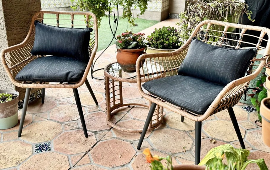 wicker chairs and table with black seat ushions on porch