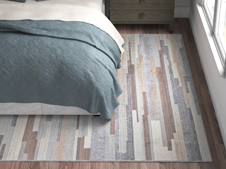 brown, blue, and gray area rug under bed