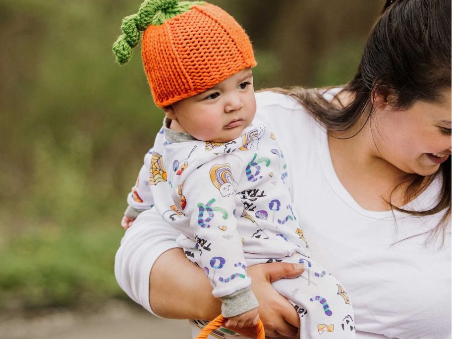 A baby wearing a pumpkin beanie and Burt's Bees Halloween Pajamas