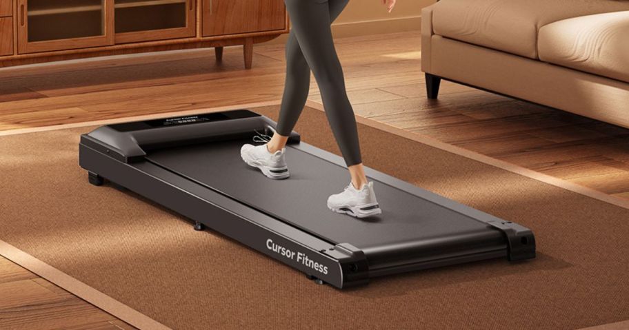 woman walking on CURSOR FITNESS Under Desk Treadmill with Full-Screen Display in living room