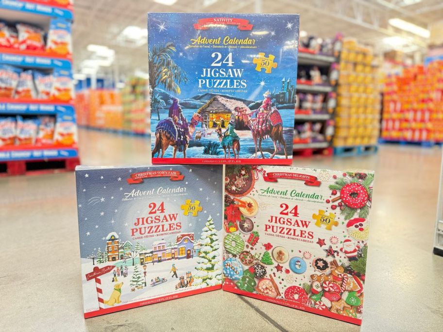 three advent calendar puzzle sets on display in a sams club