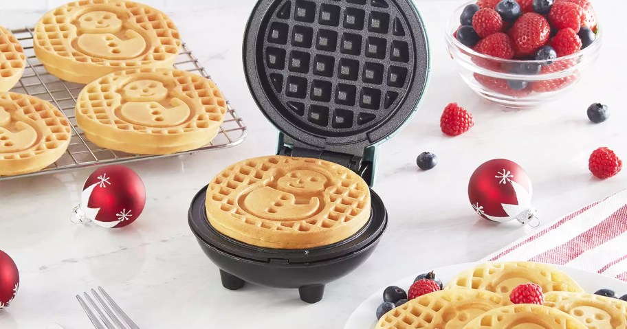 plate of snowman waffles next to mini waffle maker