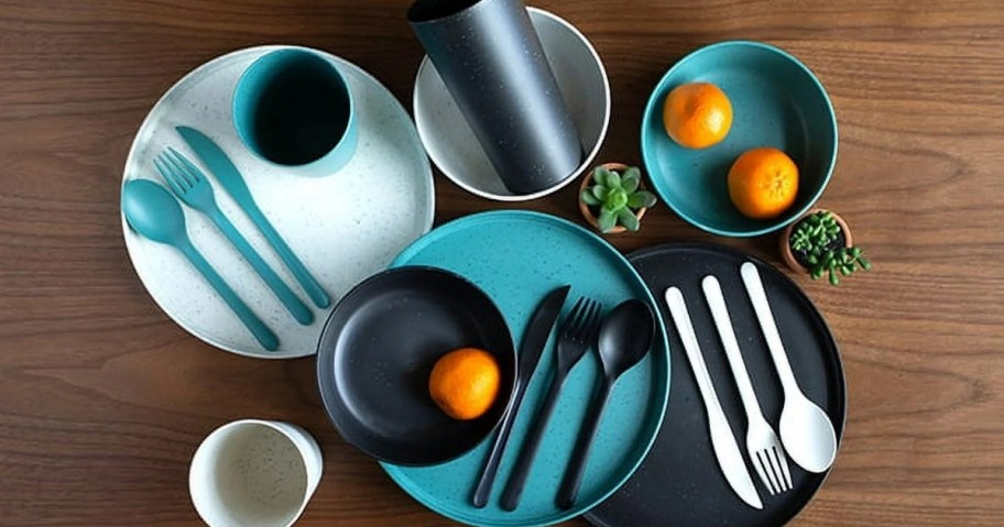 set of white, blue, and teal plastic plates, cups, bowls and flatware on a table