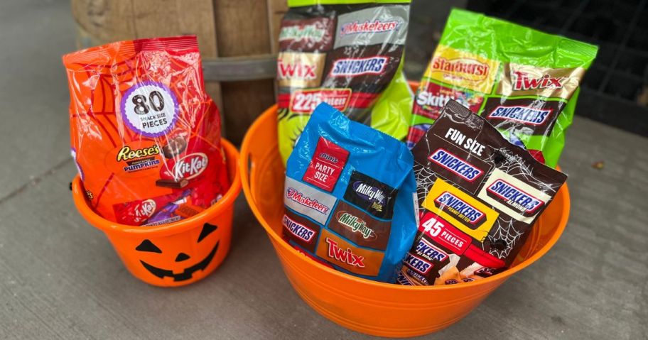 Halloween buckets filled with large bags of Halloween candy