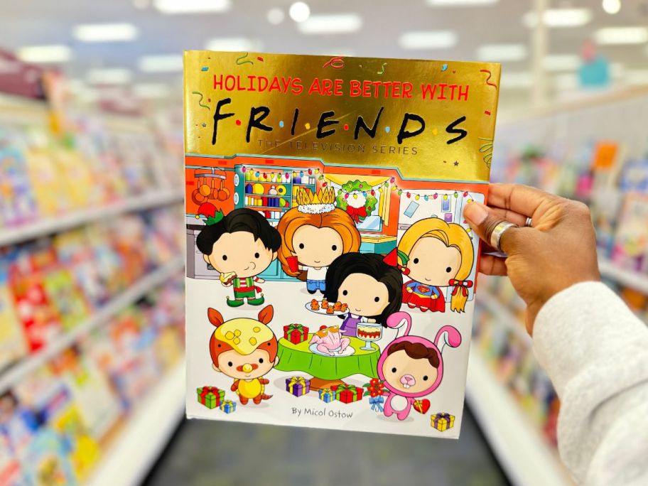 hand holding Holidays are better with friends book in store