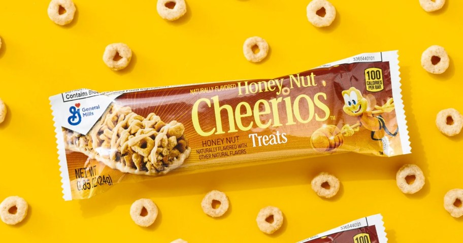 Honey Nut Cheerios Breakfast Bar on yellow background surrounded by cereal pieces