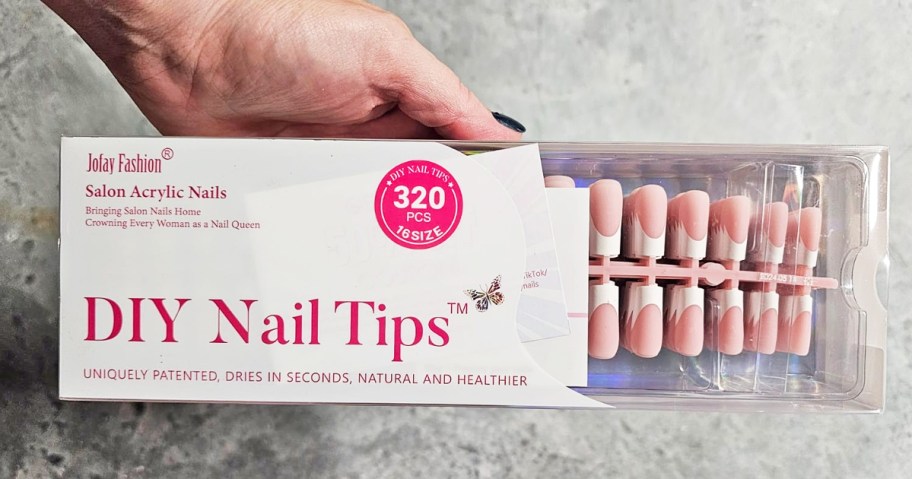 hand holding a boxed set of french tip nails