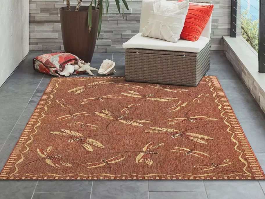 A Liora Manne Carmel Dragonfly Indoor Outdoor Rug in a conservatory