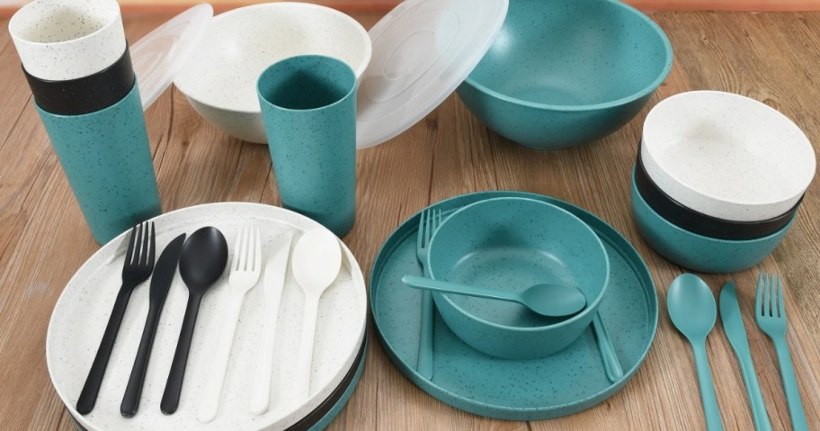 set of white, blue, and teal plastic plates, cups, bowls and flatware on a table