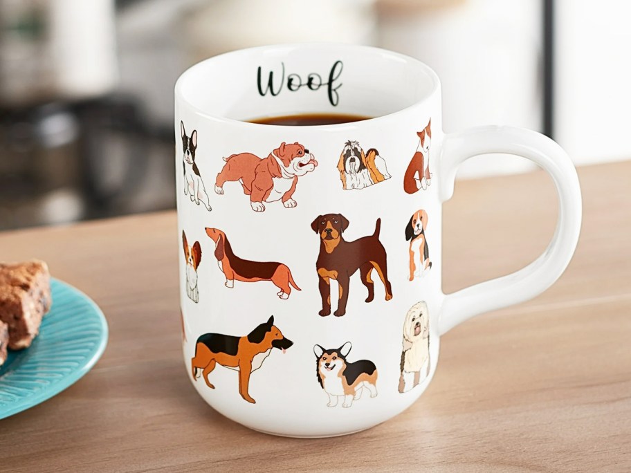 white mug covered in dogs that says "woof"