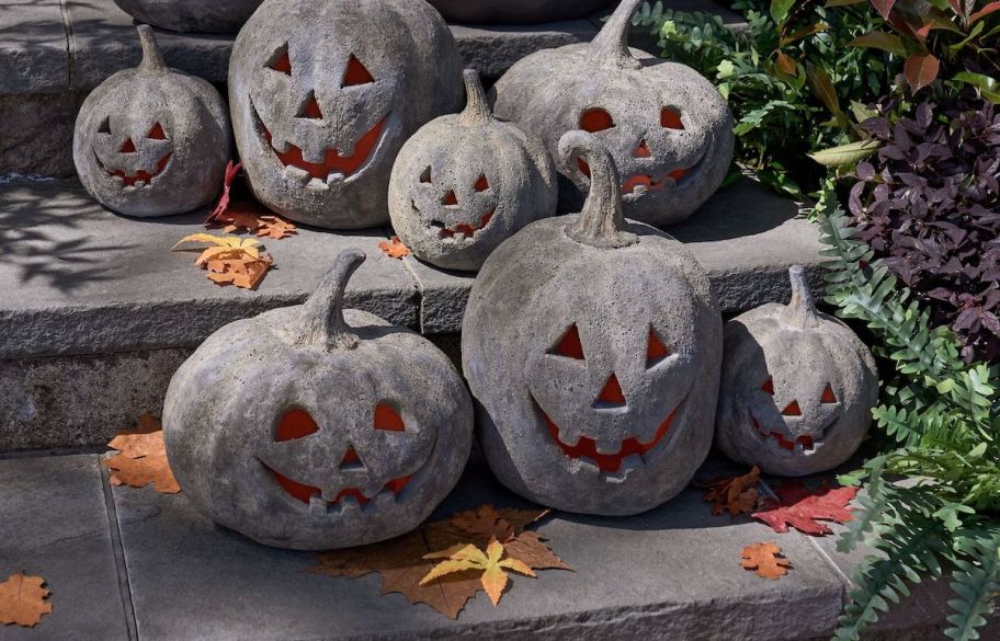different sizes of black terracotta jack o lanterns on stoop