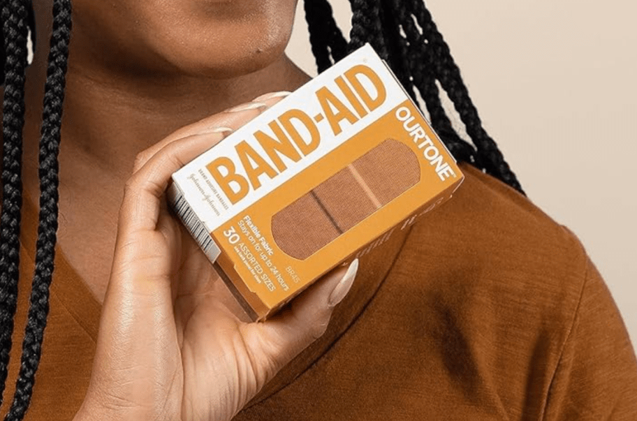 woman holding box of band-aids